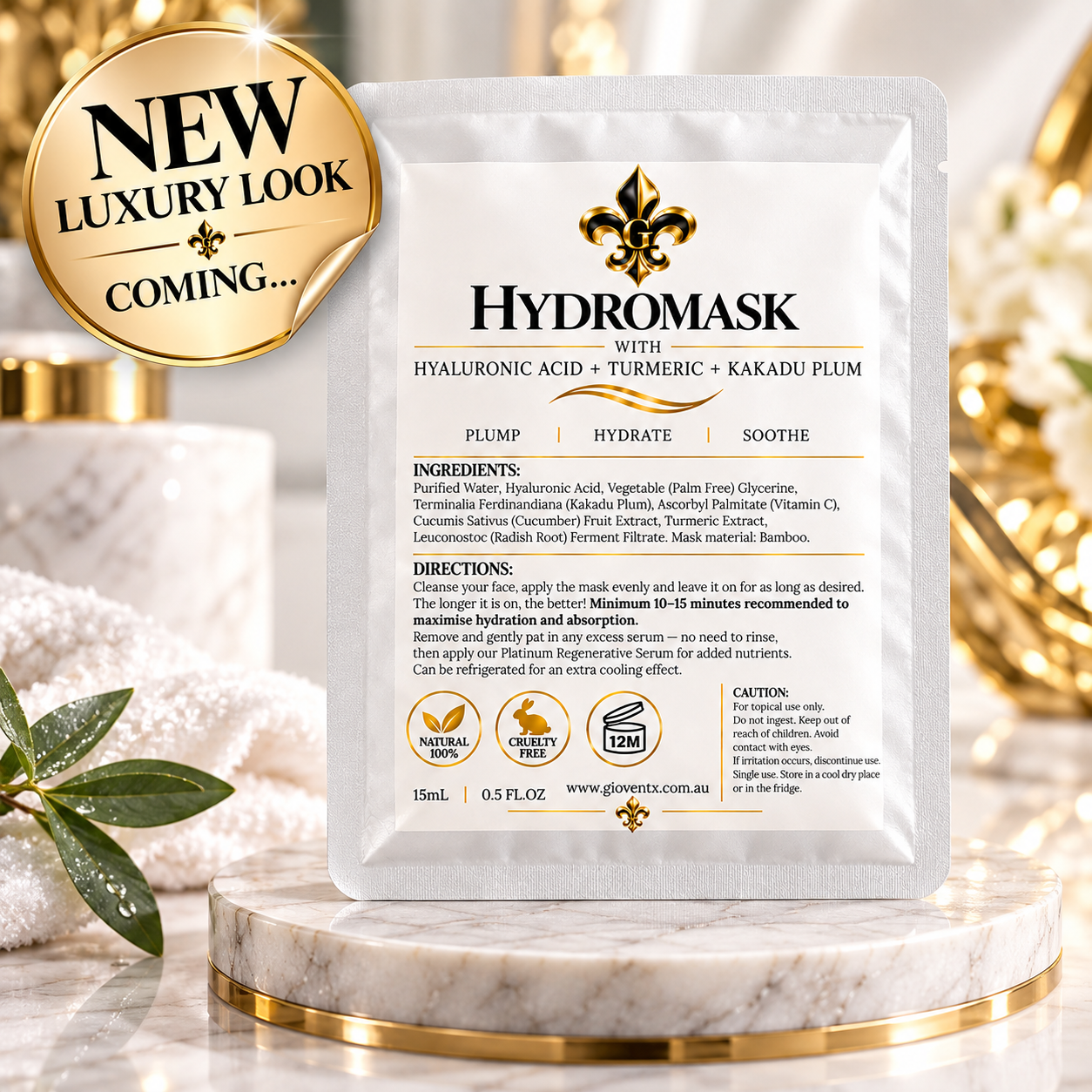 A single Hydromask face mask sachet centered on a marble pedestal with a gold circular badge reading 'NEW LUXURY LOOK 